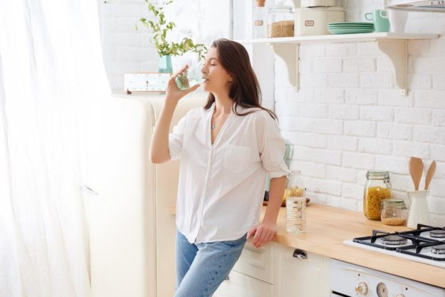 a woman drinking water and giving an example of how to detox from alcohol