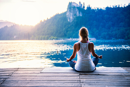 woman practicing mindfulness meditation mindfulness therapy by the lake