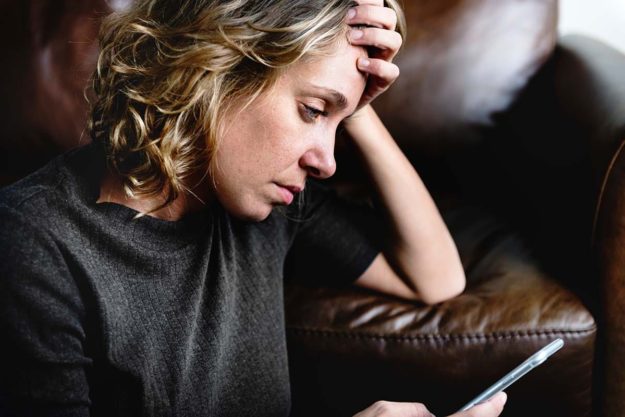 a woman reading about the heroin epidemic on her phone