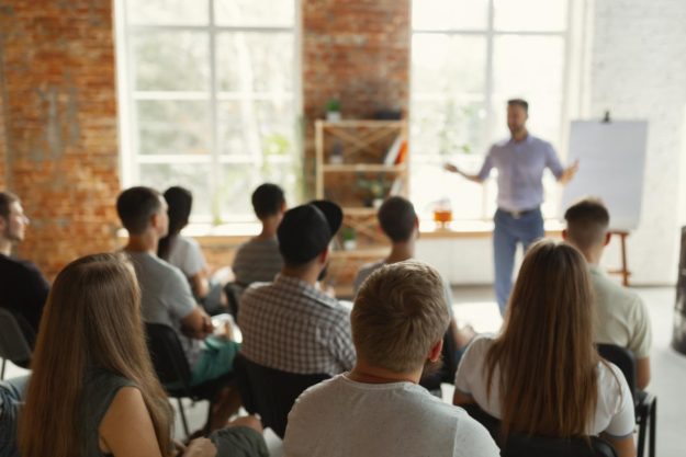 man speaking in front of group during a typical day at addiction treatment