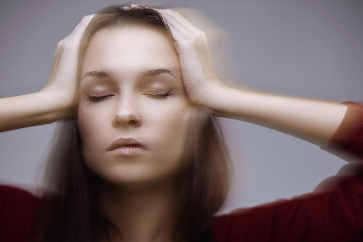 woman with hands on head feeling the effects of alcohol on her body