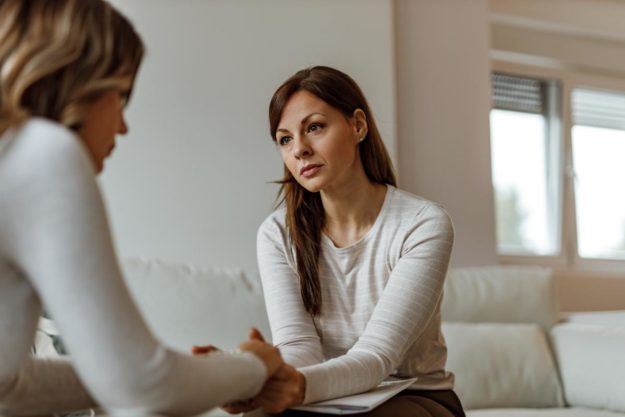 woman holding hands of another while explaining more about portland drug treatment centers