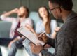 man writing on clipboard explaining types of addiction