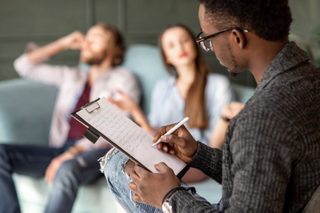 man writing on clipboard explaining types of addiction