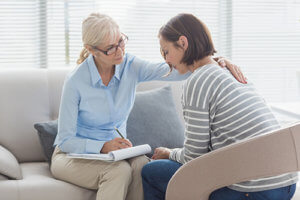 Counselor and woman chatting about drug addiction treatment in Oregon.