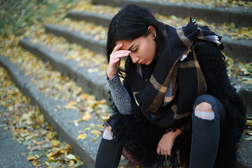 woman sitting on steps wonders how to detox your body from drugs