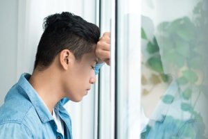 A man leans against a window has he deals with the side effects of xanax