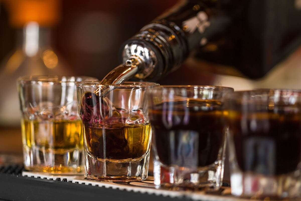 a bartender pouring drinks while asking is alcohol a stimulant