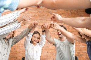 people in a circle raising and holding hands at an alcohol rehab center near West Linn 