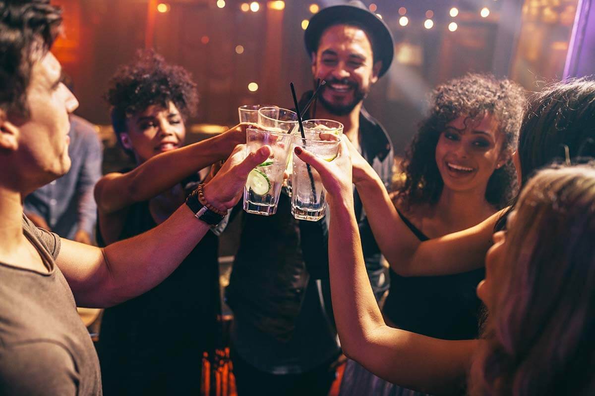 group of friends clinking glasses during a casual drinking outing