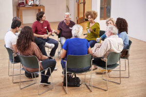 a group of people sit in a circle and talk about the advantages of a rehab center near oregon city