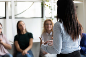 a woman talks about the advantages of a portland heroin rehab center to a group