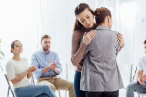 a woman hugs another woman at a heroin rehab center near Tualatin