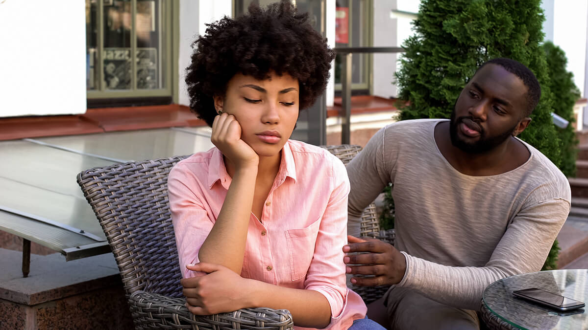 a man tries to comfort a woman as he wonders how to help an alcoholic