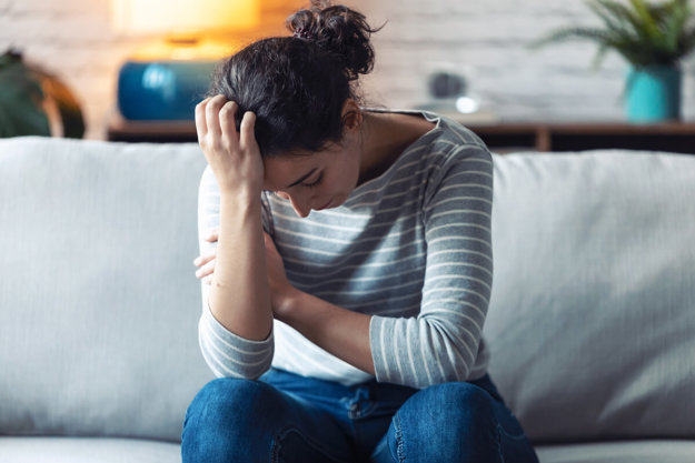 a woman holds her head as she thinks about the side effects of hydrocodone