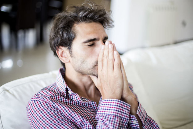 a man folds his hands in front of his face as he thinks about the substance use definition