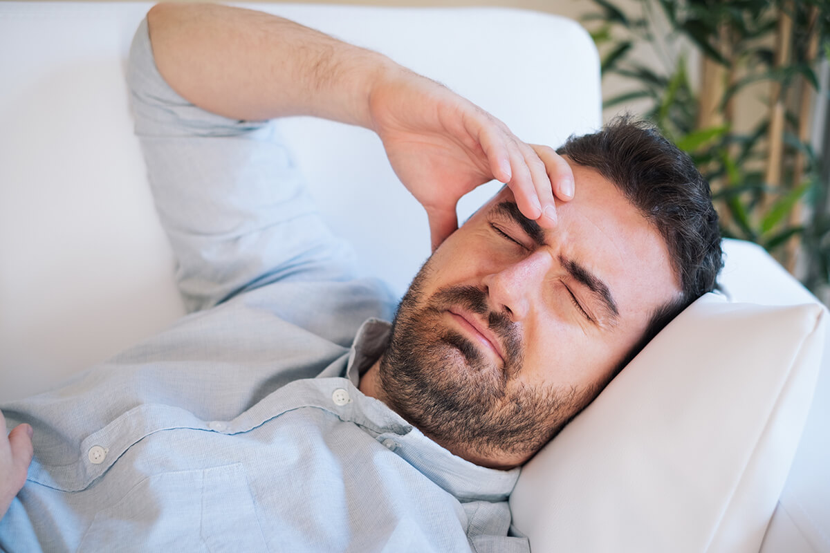 a man holds his head after combining alcohol and xanax