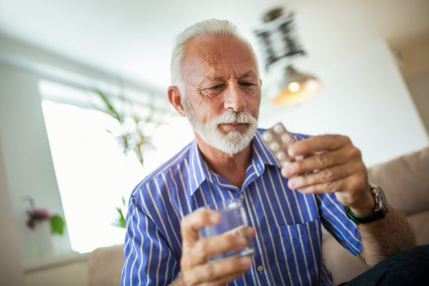 a man stares at pills and wonders about the difference between dependence vs addiction