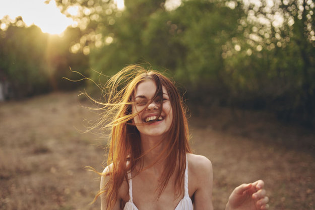 a woman smiles as she experiences alcohol addiction recovery