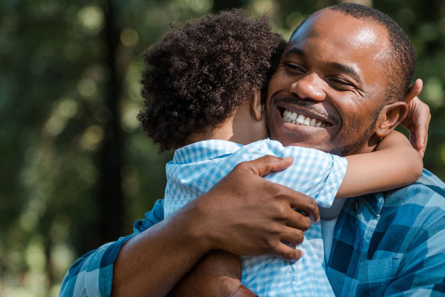 a man hugs his son as he considers different recovery programs