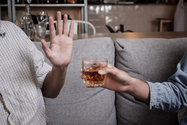 a man refuses a drink as he wonders how can i stop drinking