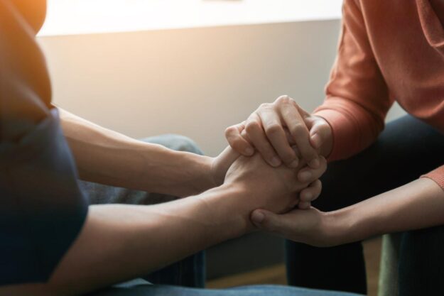 Two people holding hands and trying to deal with the opioid epidemic