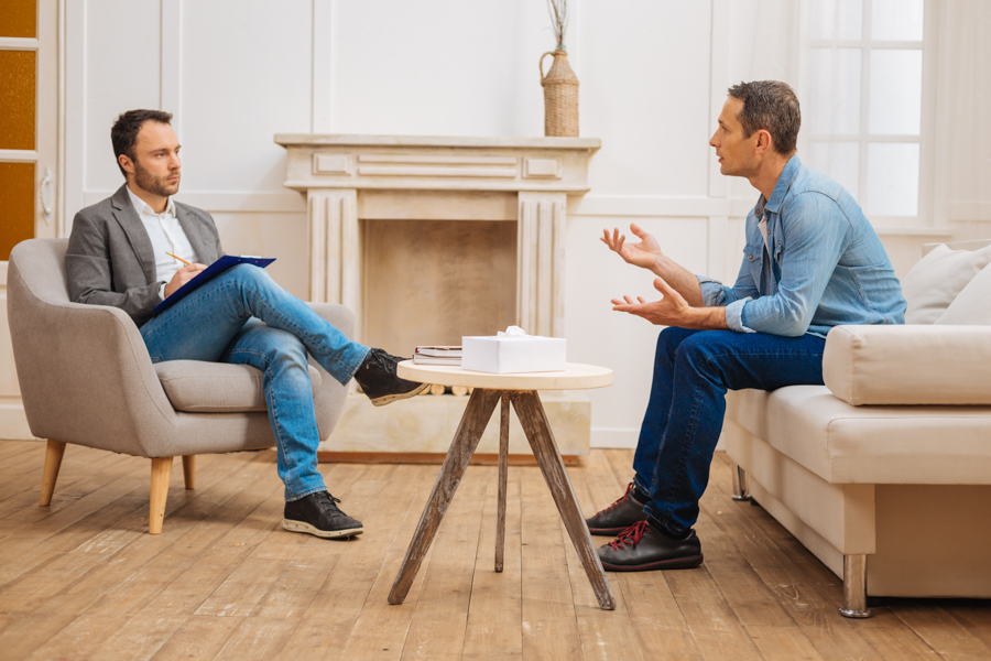 man sitting in therapy in men's rehab program