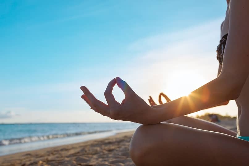 person on beach meditating on step 11