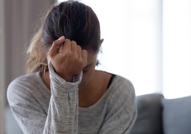 oman with head in her hand feeling anxious