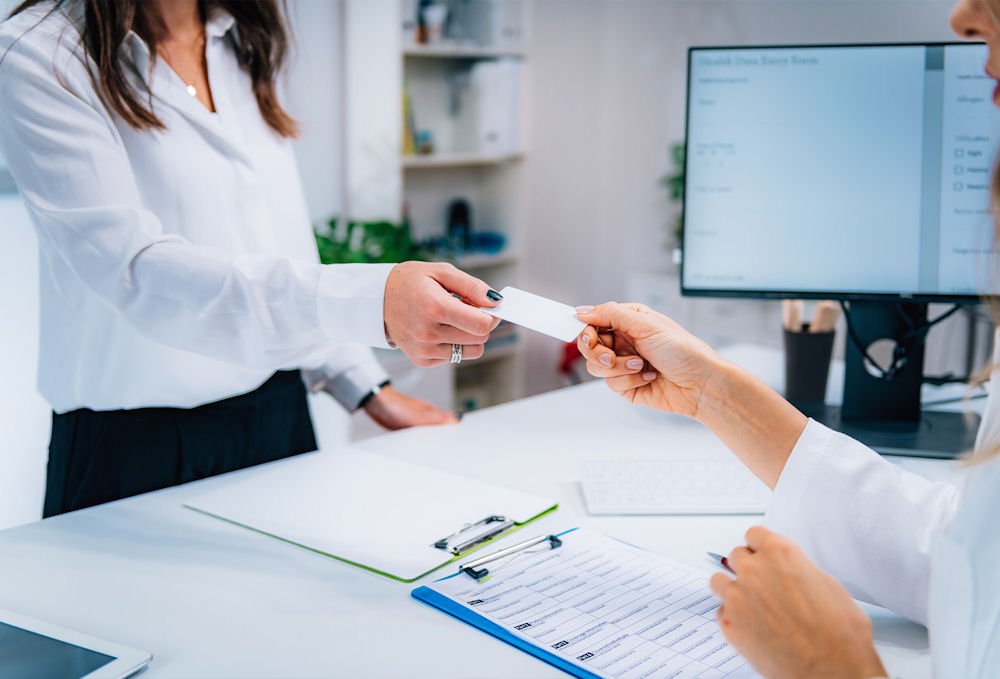 receptionist accepting insurance card for rehab