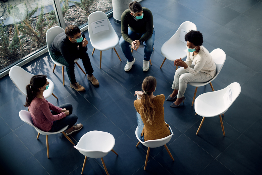 small group of people sitting in chair meeting for addiction therapy