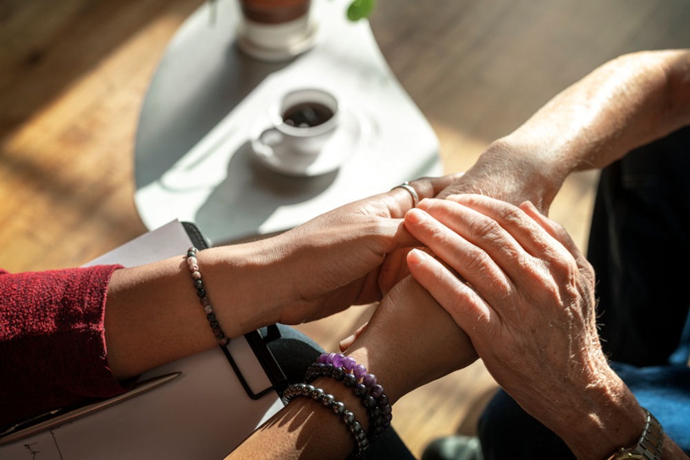 family holding hands over a cup of coffee