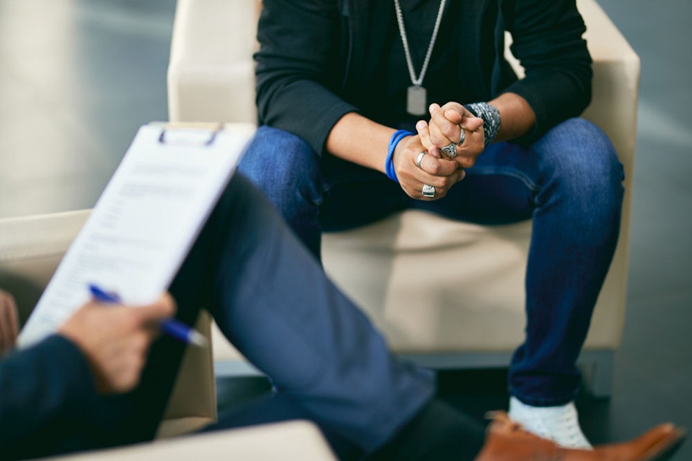 man sitting in chair across from therapist