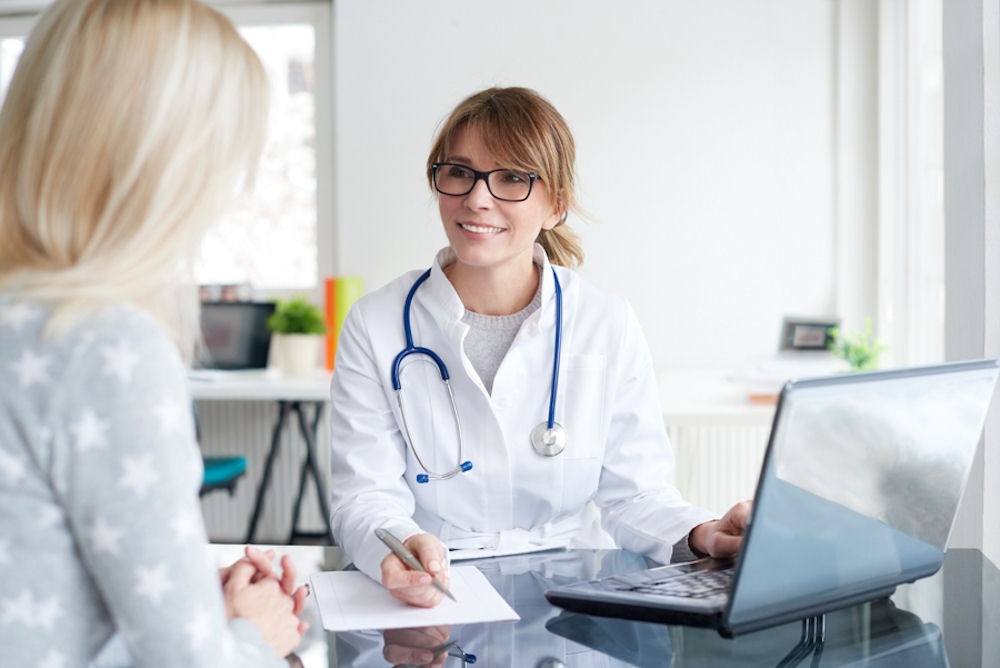 doctor sitting at her desk discussing treatment options with patient