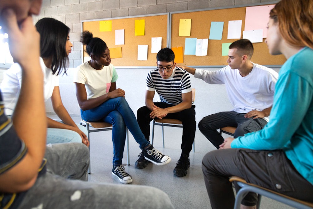 college age young adults sitting in a circle for group mental health therapy