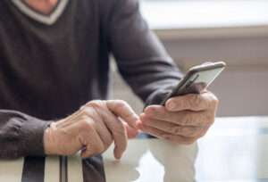 senior using phone to contact rehab