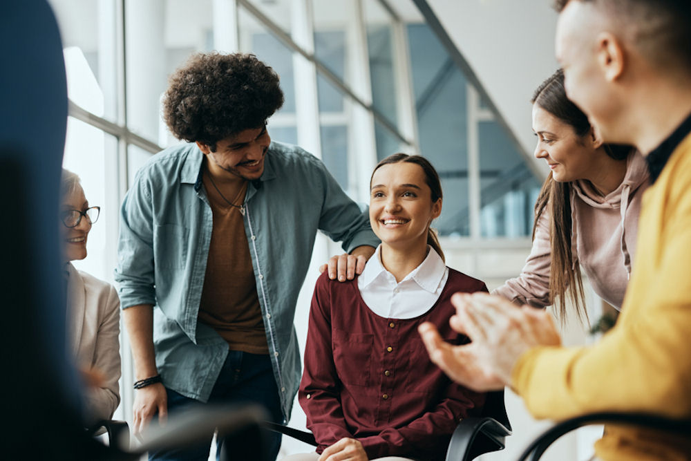 young woman being applauded during group therapy session