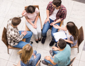 overhead view of group therapy with individuals sitting in chairs