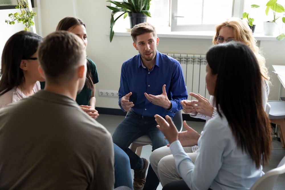 man in blue shirt talking during group session